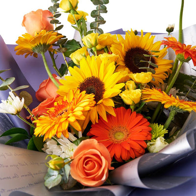 Ray of Hope Sunflower Bouquet. Sunflowers, Gerbera, Roses, Daisies, Spray Roses, and Greens in a Floral Wrap and Tied with Designer Ribbon. Mixed Flower Gifts from Heart & Thorn USA - Same Day USA Delivery.