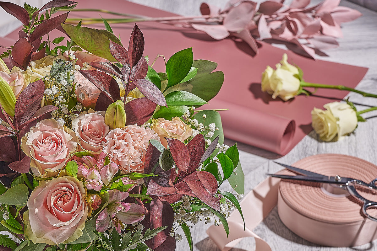 Florist completing a floral arrangement in a California studio