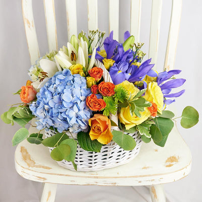 Irises in Paradise Mixed Arrangement. Irises, Roses, Hydrangea, Lilies, Spray Roses, Daisies, and Greens in a Charming Wicker Basket. Mixed Floral Gifts from Heart & Thorn USA - Same Day USA Delivery.