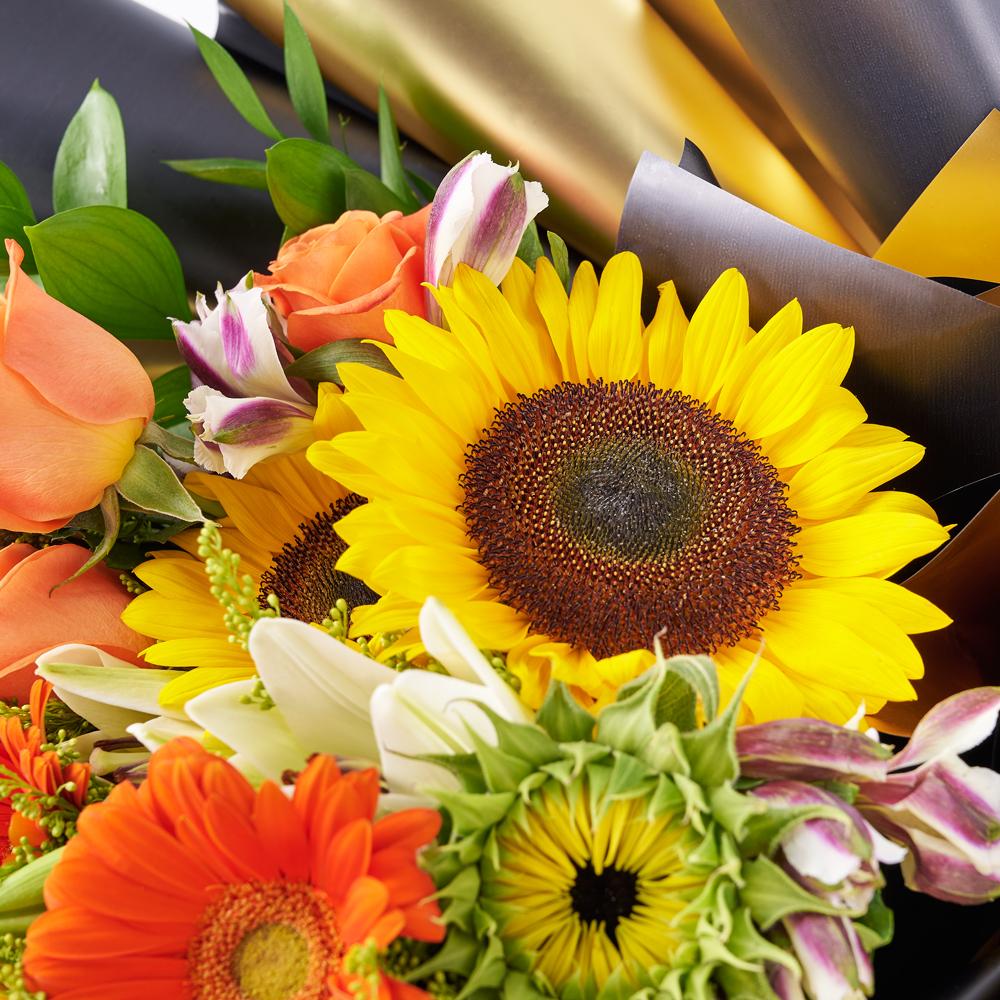 Let Your Light Shine Sunflower Bouquet. Sunflowers, Gerbera, Roses, Solidago, Lilies, Alstroemeria, Daisies, Eucalyptus, and Ruscus Gathered in a Floral Wrap and Tied with Designer Ribbon. Mixed Flower Gifts from Heart & Thorn USA - Same Day USA Delivery.