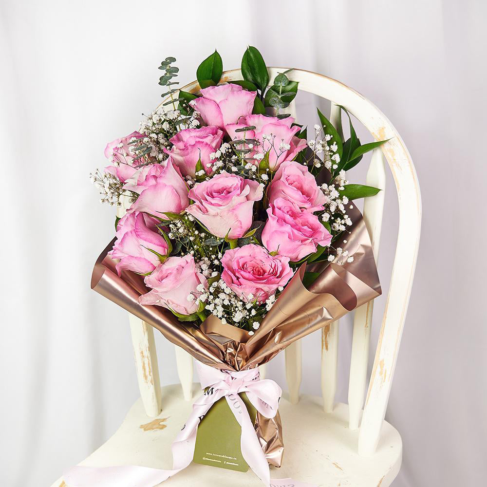 Mother's Day 12 Stem Prink Rose Bouquet. Dozen Pink Roses with Baby’s Breath and Greens in a Floral Wrap and Tied with Designer Ribbon. Flower Gifts from Heart & Thorn USA - Same Day USA Delivery.